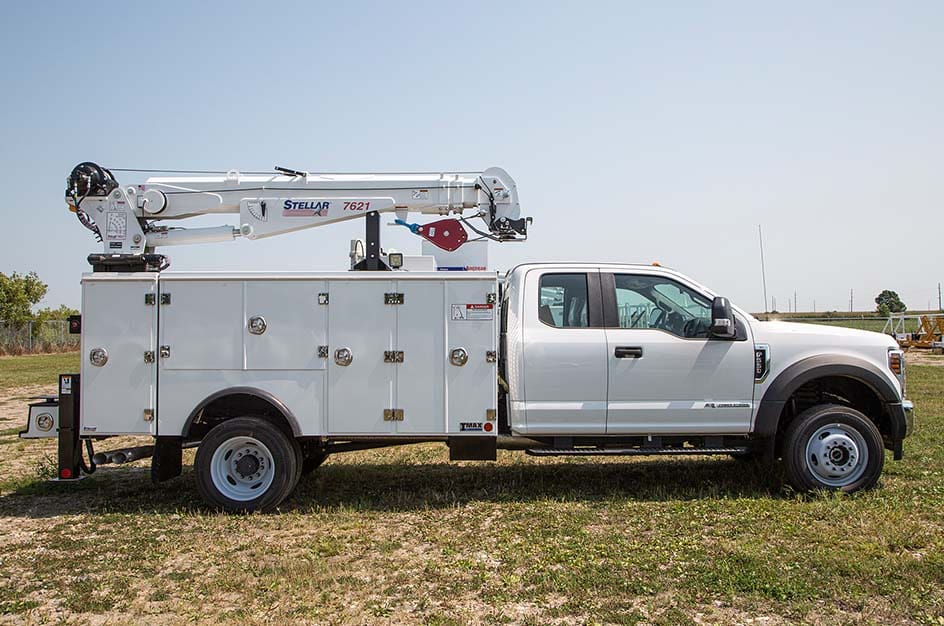 A white TMAX 1 mechanic truck facing to the right on green grass
