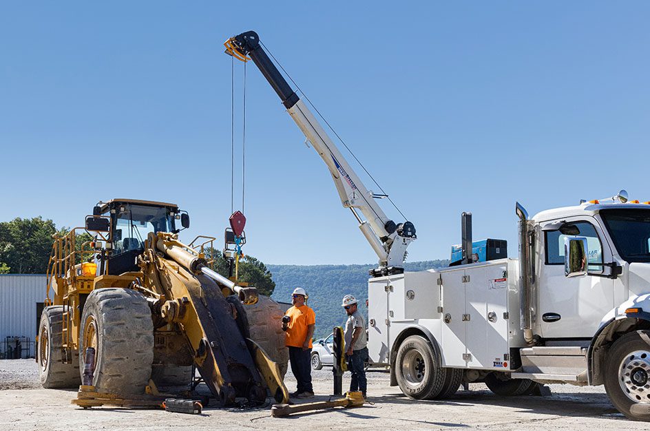 white hydraulic service crane with equipment and water in background